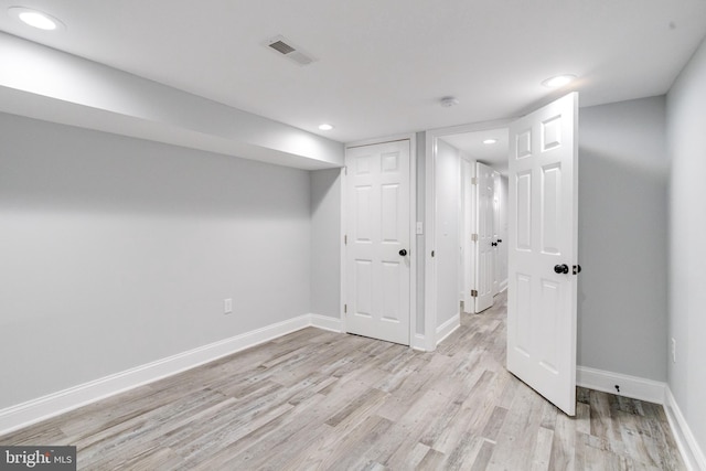 basement with light hardwood / wood-style flooring