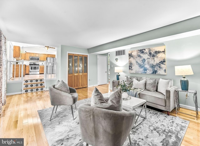 living room featuring light wood-type flooring and ceiling fan