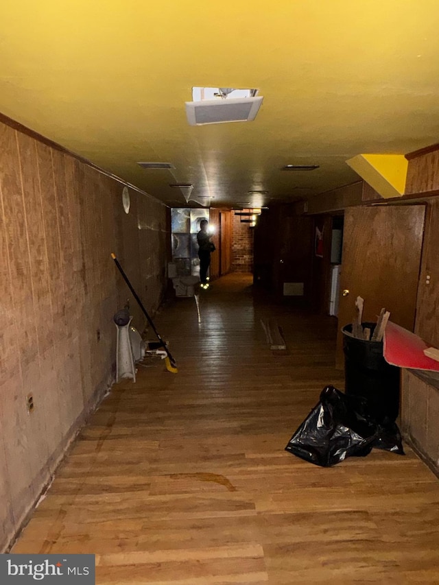 corridor with wooden walls and wood-type flooring