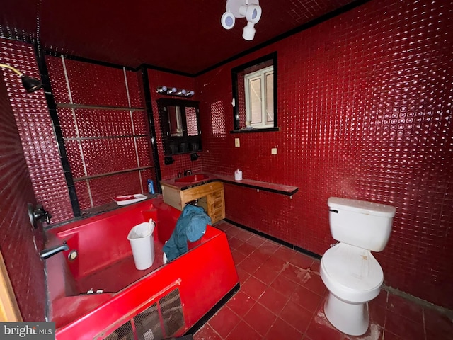 bathroom with toilet, sink, tile patterned floors, and crown molding