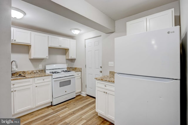 kitchen with light wood-type flooring, white appliances, sink, and white cabinets