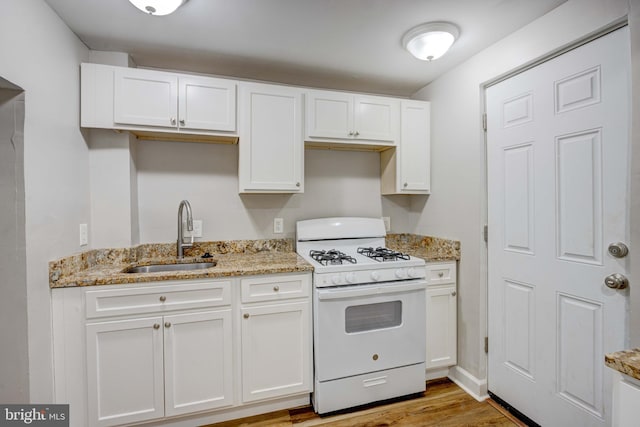 kitchen featuring light wood-type flooring, white cabinetry, sink, and white range with gas cooktop