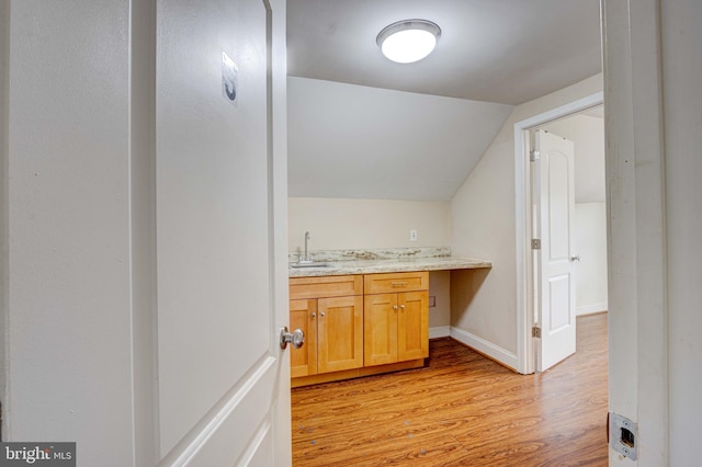 bathroom with vanity, lofted ceiling, and wood-type flooring