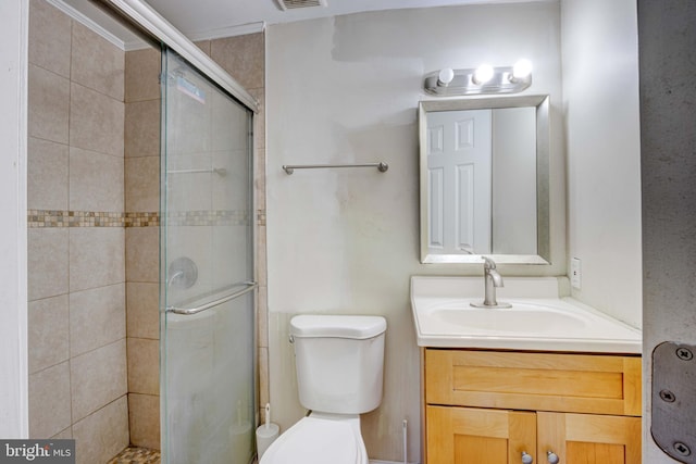 bathroom featuring a shower with shower door, vanity, toilet, and crown molding