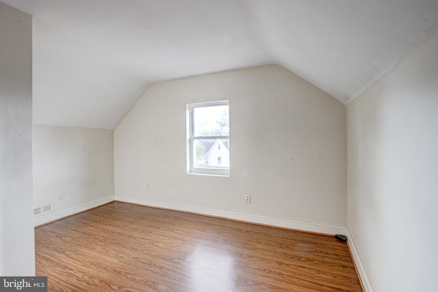 additional living space featuring light wood-type flooring and lofted ceiling