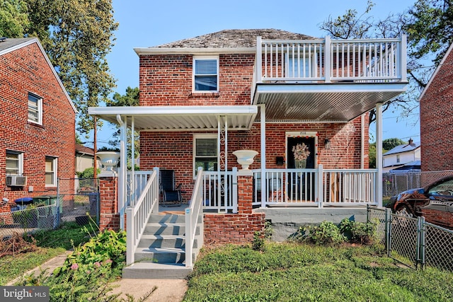 view of front facade featuring a porch, a balcony, and cooling unit