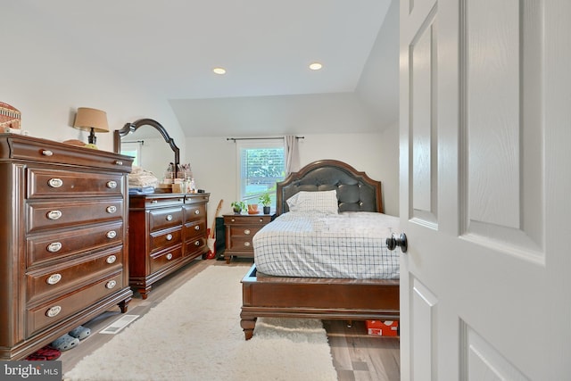 bedroom featuring light hardwood / wood-style floors and vaulted ceiling