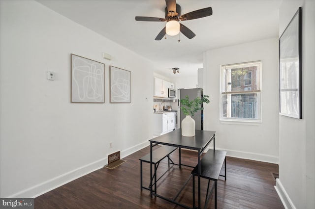 dining area with dark wood-type flooring and ceiling fan