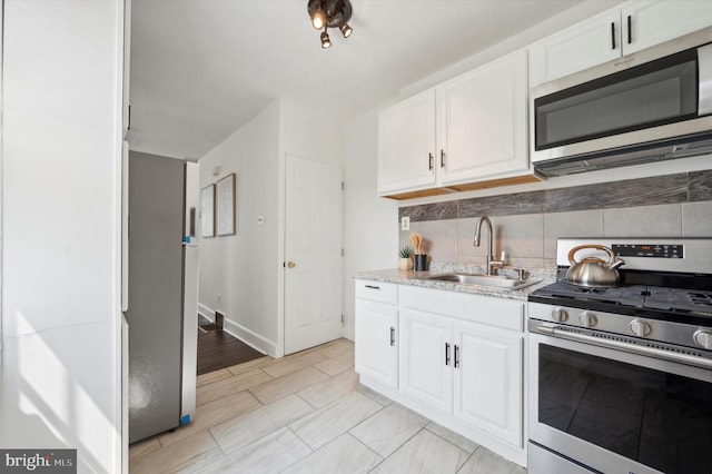 kitchen featuring sink, appliances with stainless steel finishes, white cabinetry, and tasteful backsplash