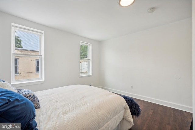 bedroom with multiple windows and hardwood / wood-style flooring