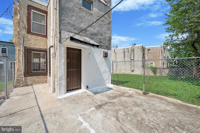 view of exterior entry with a patio area and a yard