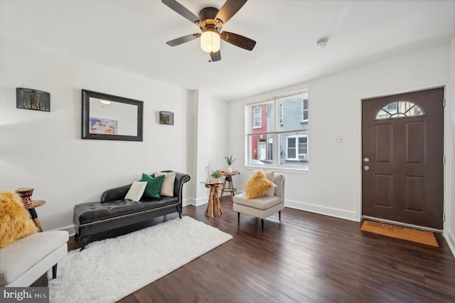 living room featuring dark wood-type flooring and ceiling fan