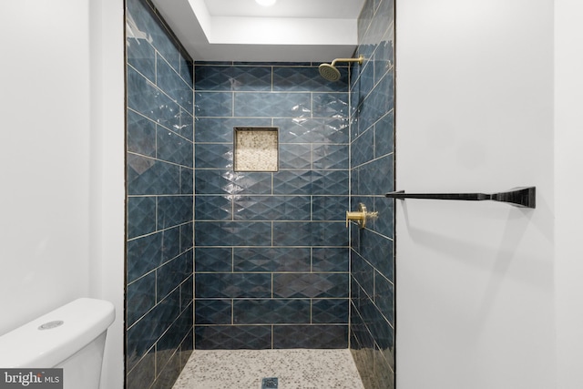 bathroom with toilet and a tile shower