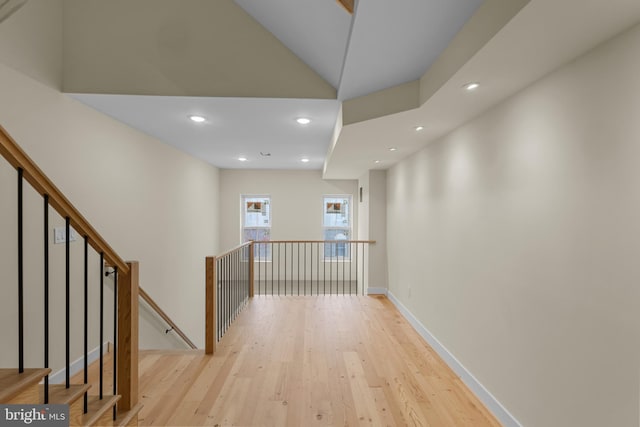 hall featuring vaulted ceiling and light hardwood / wood-style flooring