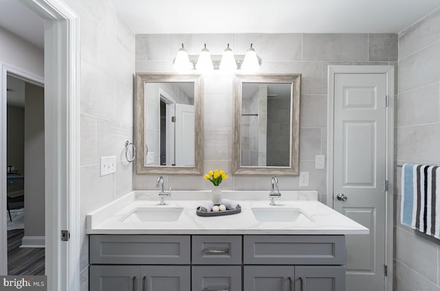 bathroom with vanity and tile walls