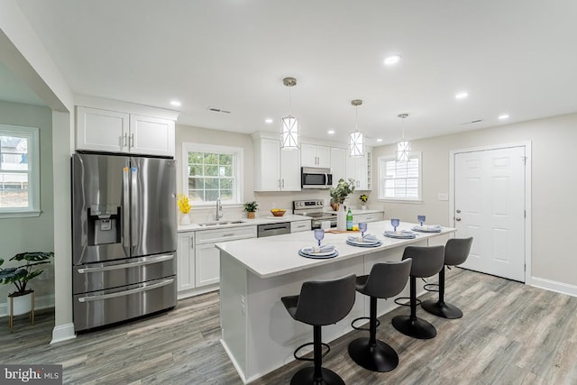 kitchen featuring a wealth of natural light, white cabinetry, sink, and appliances with stainless steel finishes