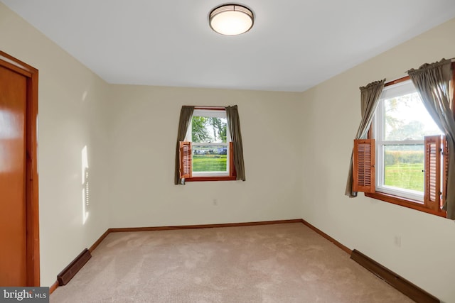 empty room featuring a healthy amount of sunlight and light colored carpet