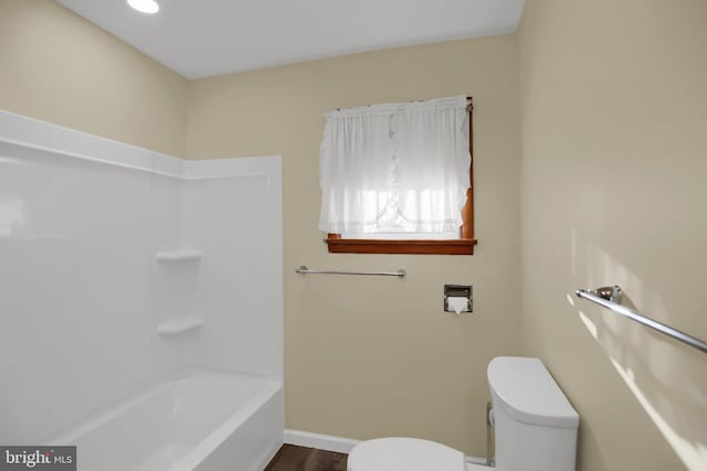 bathroom with toilet, wood-type flooring, and washtub / shower combination