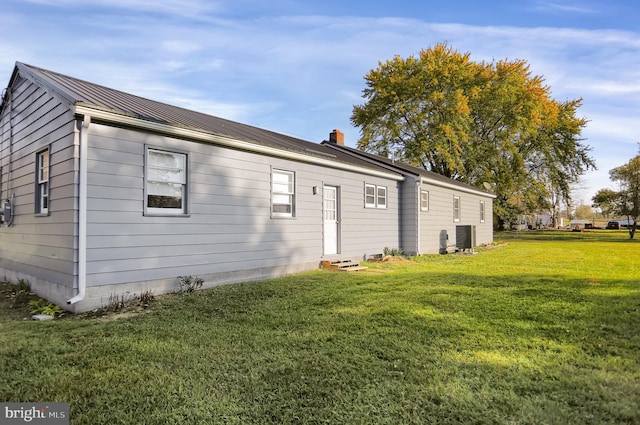 back of house featuring central AC and a yard