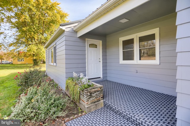 view of exterior entry with a yard