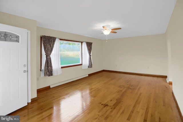 unfurnished room featuring ceiling fan, wood-type flooring, and baseboard heating