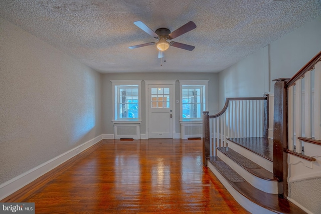 entrance foyer with hardwood / wood-style floors, ceiling fan, and a textured ceiling