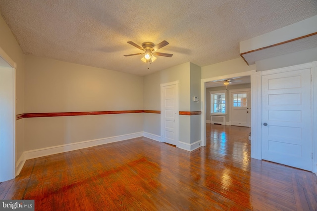 unfurnished room featuring dark wood-type flooring, a textured ceiling, and ceiling fan