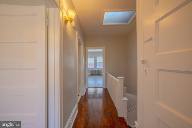 corridor featuring radiator, dark hardwood / wood-style floors, and a skylight