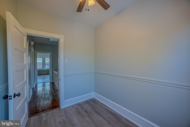 corridor with radiator heating unit and hardwood / wood-style flooring