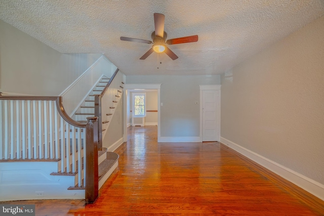 interior space featuring wood-type flooring, ceiling fan, and a textured ceiling