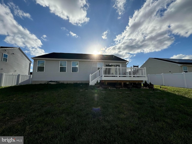 back of property featuring a lawn and a deck