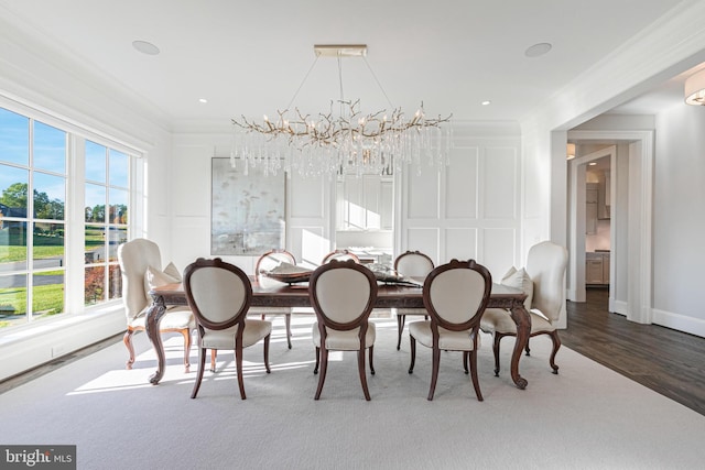 dining area with dark hardwood / wood-style floors, crown molding, a wealth of natural light, and an inviting chandelier