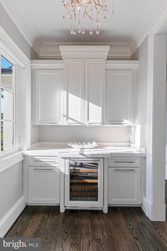 bar featuring white cabinets, beverage cooler, dark wood-type flooring, and a notable chandelier