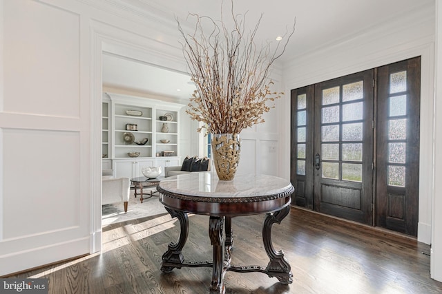 entryway with hardwood / wood-style flooring and ornamental molding