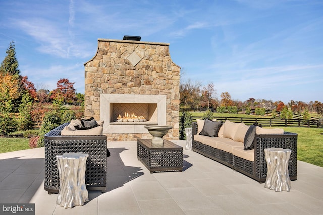 view of patio with an outdoor living space with a fireplace