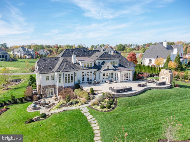 back of house featuring an outdoor living space with a fireplace, a yard, a patio, and french doors