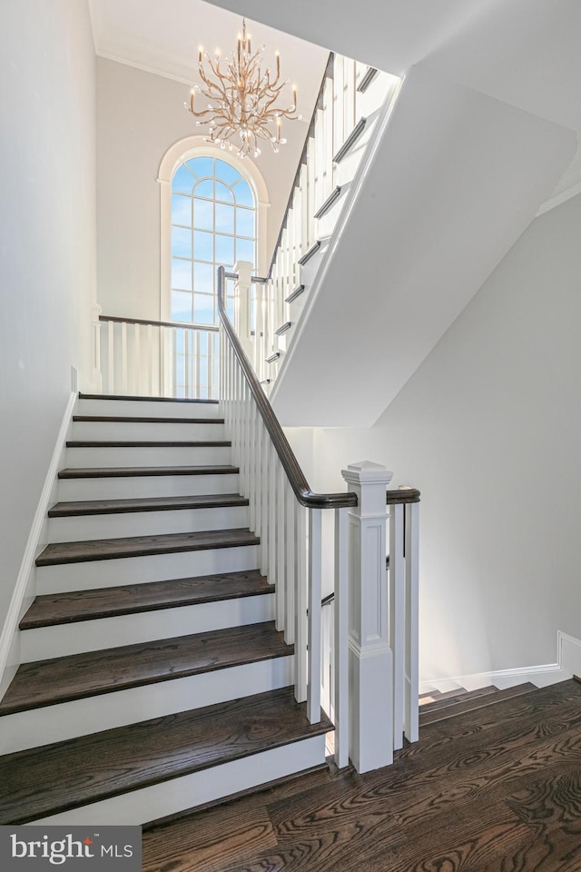 stairs featuring hardwood / wood-style floors and a chandelier