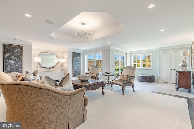 living room with a notable chandelier, a raised ceiling, and crown molding