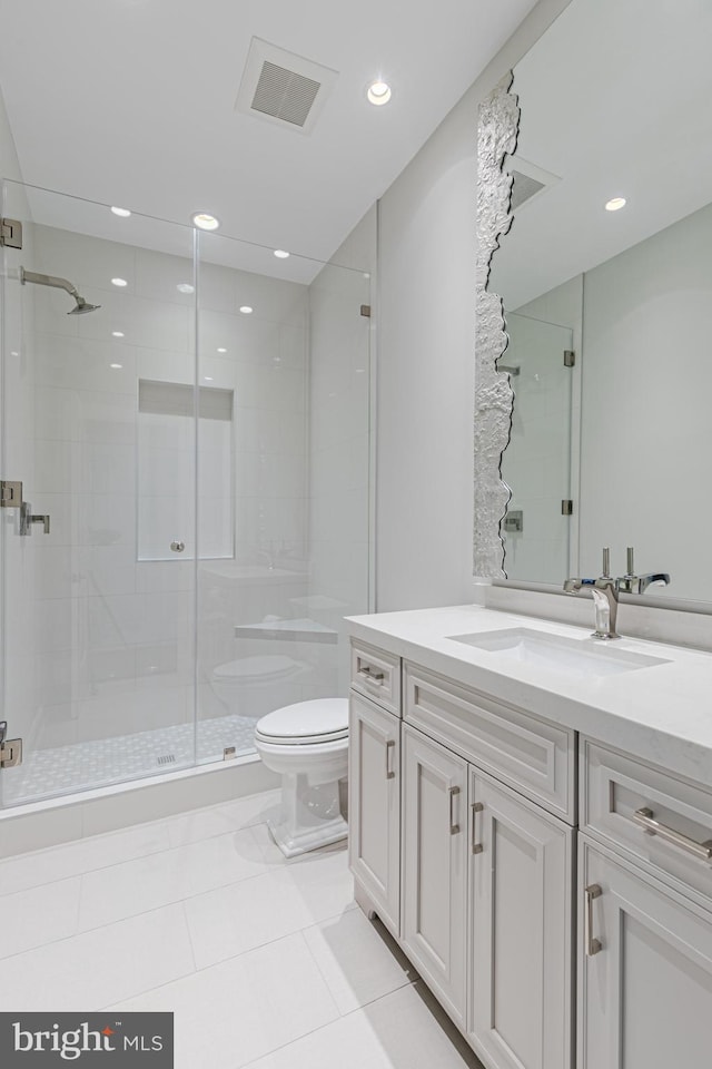 bathroom with tile patterned floors, vanity, toilet, and a shower with door