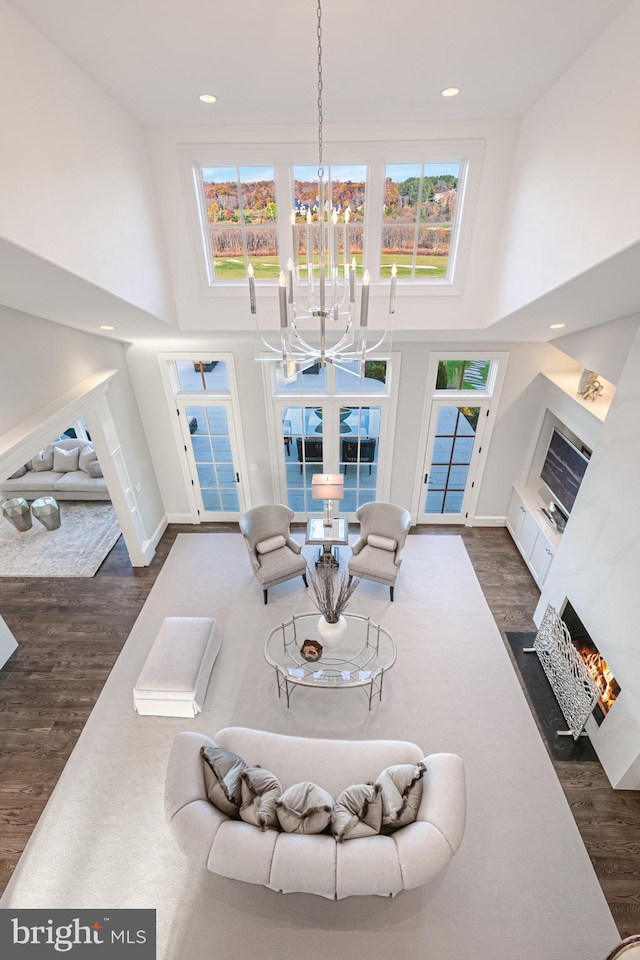 living room with plenty of natural light, dark hardwood / wood-style floors, and a high ceiling