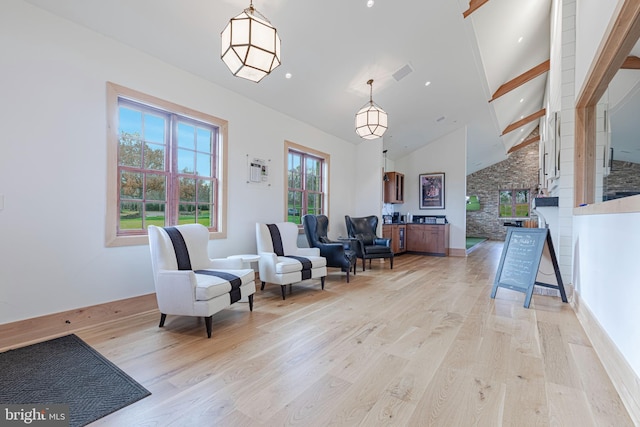 sitting room with beam ceiling, high vaulted ceiling, and light wood-type flooring