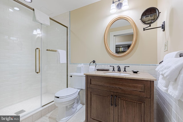 bathroom featuring vanity, a shower with door, and tile walls