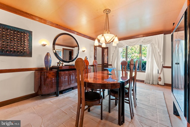 dining room with a notable chandelier, ornamental molding, and light tile patterned floors