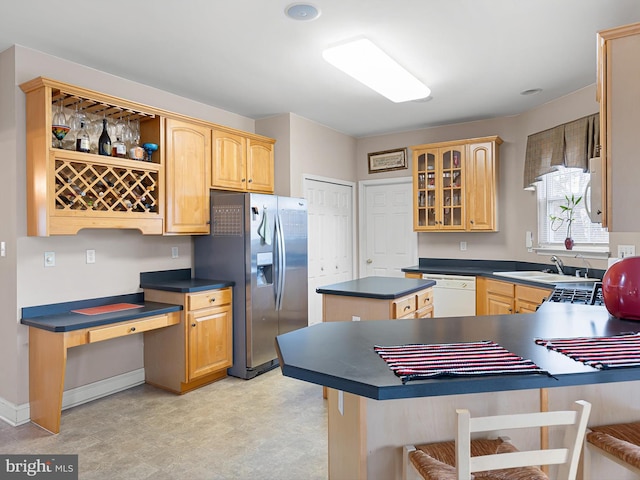 kitchen with kitchen peninsula, stainless steel refrigerator with ice dispenser, sink, and white dishwasher