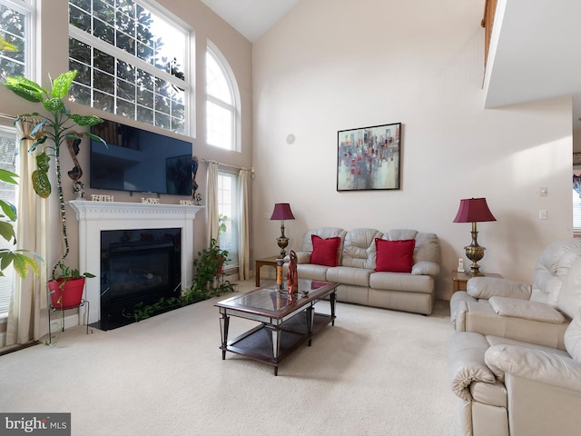 living room with high vaulted ceiling and carpet