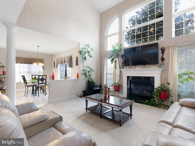 living room with a high ceiling, an inviting chandelier, and carpet flooring