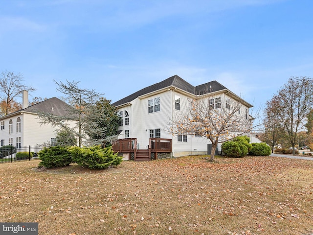 rear view of property featuring a wooden deck