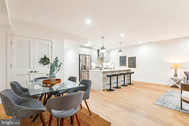 dining space with sink and light hardwood / wood-style flooring