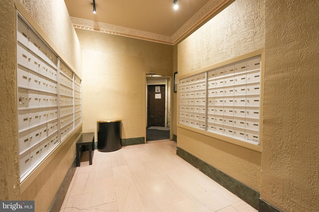 hall featuring a mail area and rail lighting