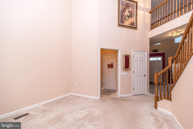 entryway with carpet floors and a high ceiling